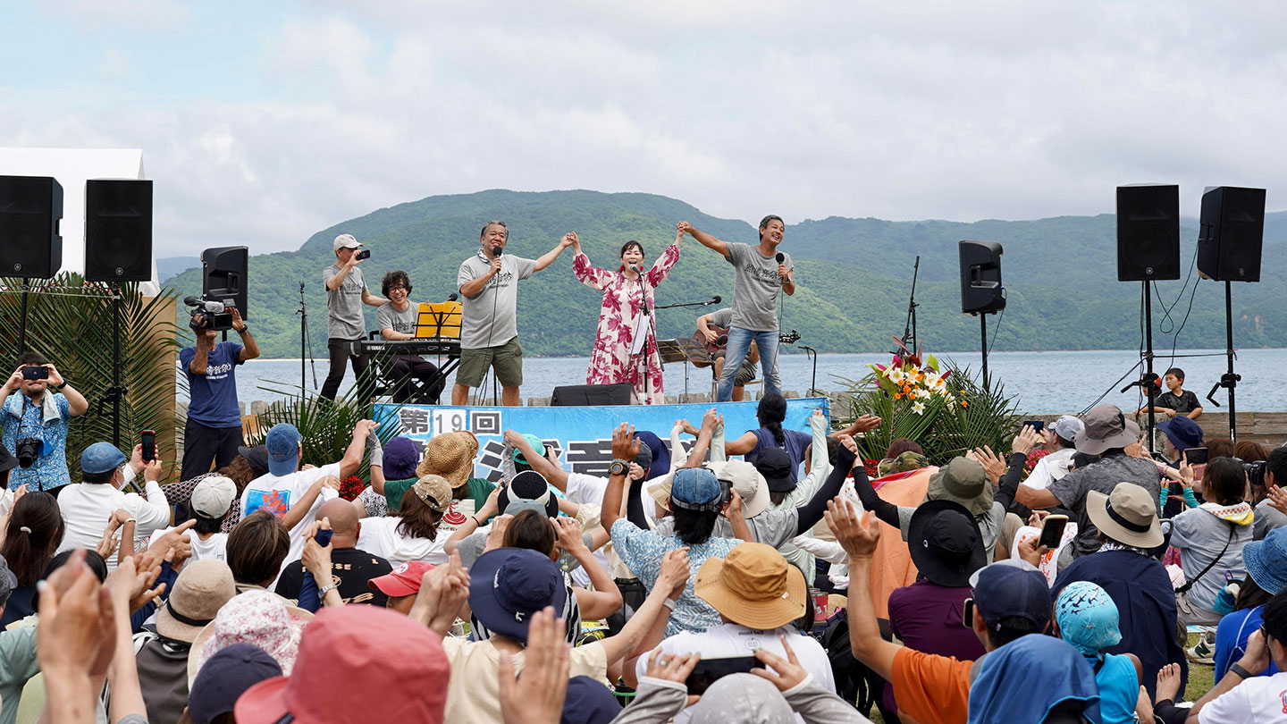 海と山にはさまれた特設ステージと、集まった観客